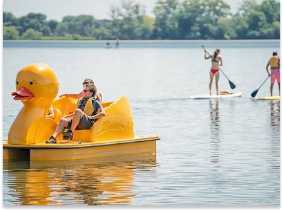 kids on a duck paddleboard and two women paddleboarding